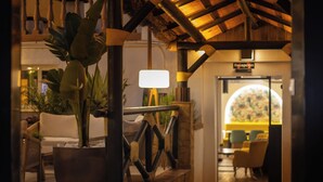 A reception area with a sign, a potted plant, and a seating area with chairs and a table. - Hotel Zen Airport with Free shuttle (Torremolinos)
