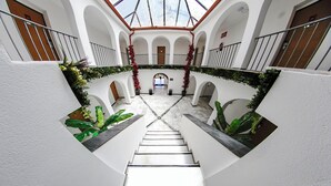 A multi-level atrium with a central staircase, white walls, and potted plants. - Hotel Zen Airport with Free shuttle (Torremolinos)