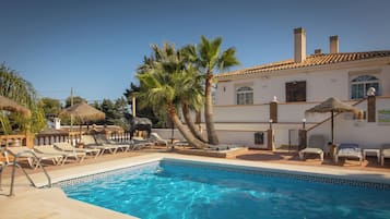 Een buitenzwembad, parasols voor strand/zwembad