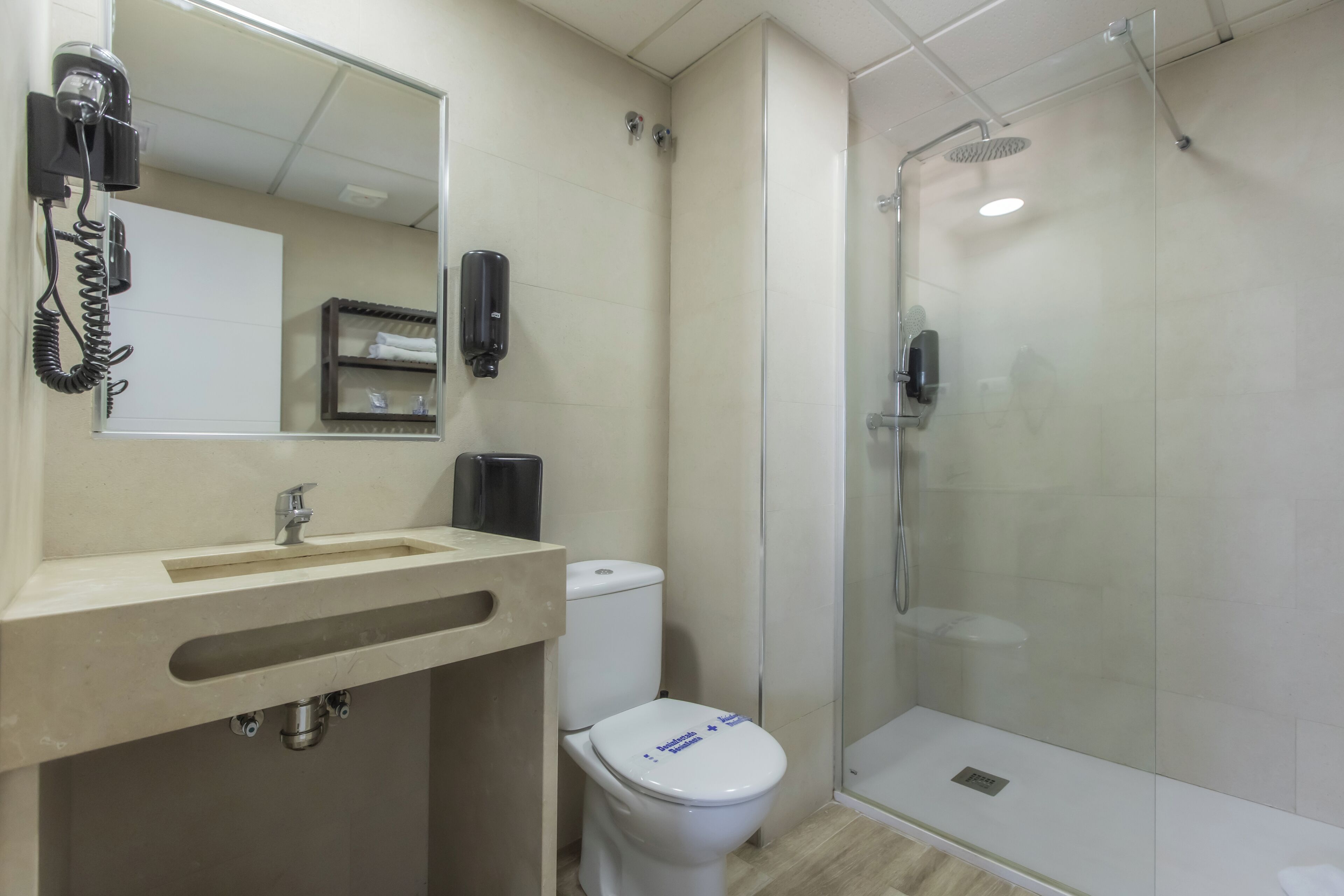 A modern bathroom with a sink, toilet, and glass-enclosed shower.