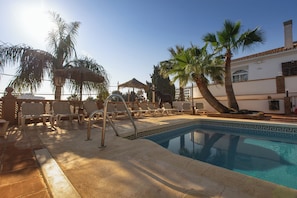 حمّام سباحة خارجي، مظلات على حمّام السباحة، مقاعد للتشمس