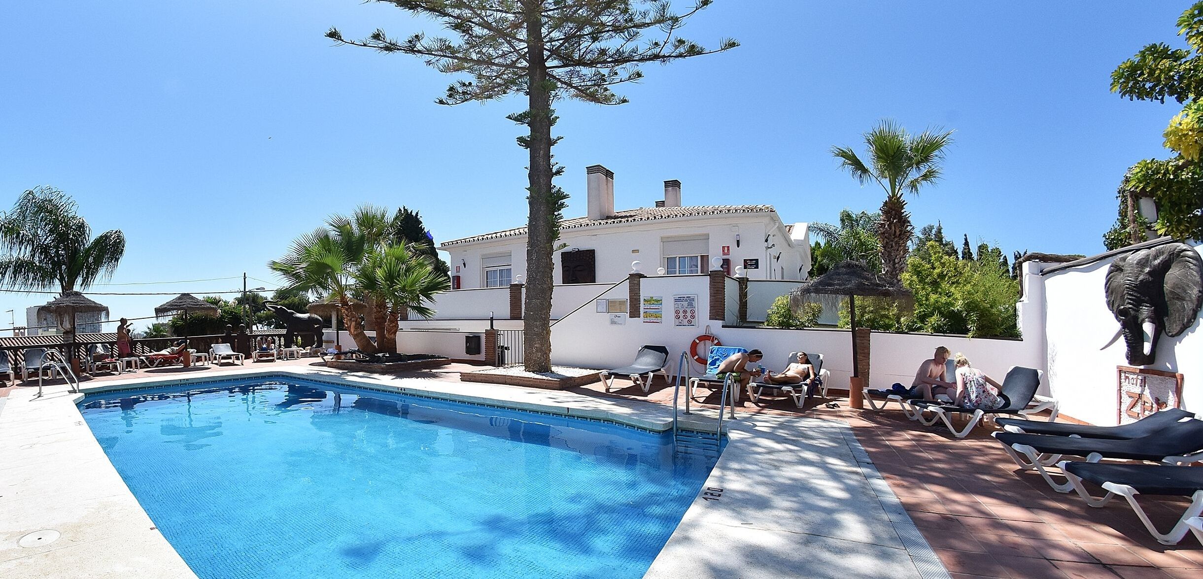 室外游泳池，池畔遮阳伞，日光浴躺椅