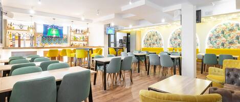 A modern restaurant interior with multiple dining tables and chairs, a bar area with a variety of bottles, and decorative wall panels.