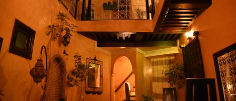 A cozy interior with a staircase, a dining area, and a balcony with plants.