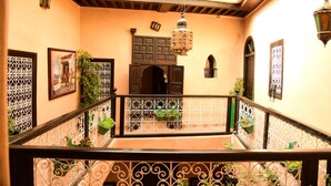 A balcony with wrought iron railings, potted plants, and a hanging lantern. - Riad du Petit Prince (Marrakech)