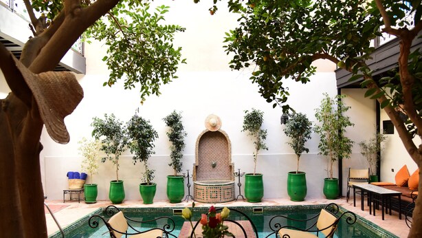 A courtyard with a pool, seating, and potted plants. - Riad du Petit Prince (Marrakech)