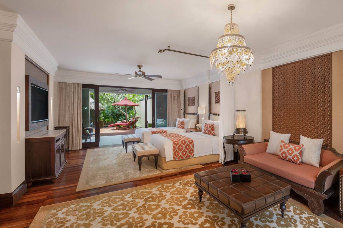 Une chambre spacieuse avec un grand lit, un canapé, une table basse et un téléviseur.
