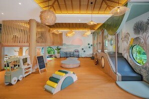 A children's play area with a slide, a toy truck, and a chalkboard sign.