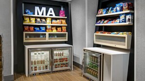 A snack and beverage display area with shelves stocked with chips and a refrigerated section with bottled water and soda.