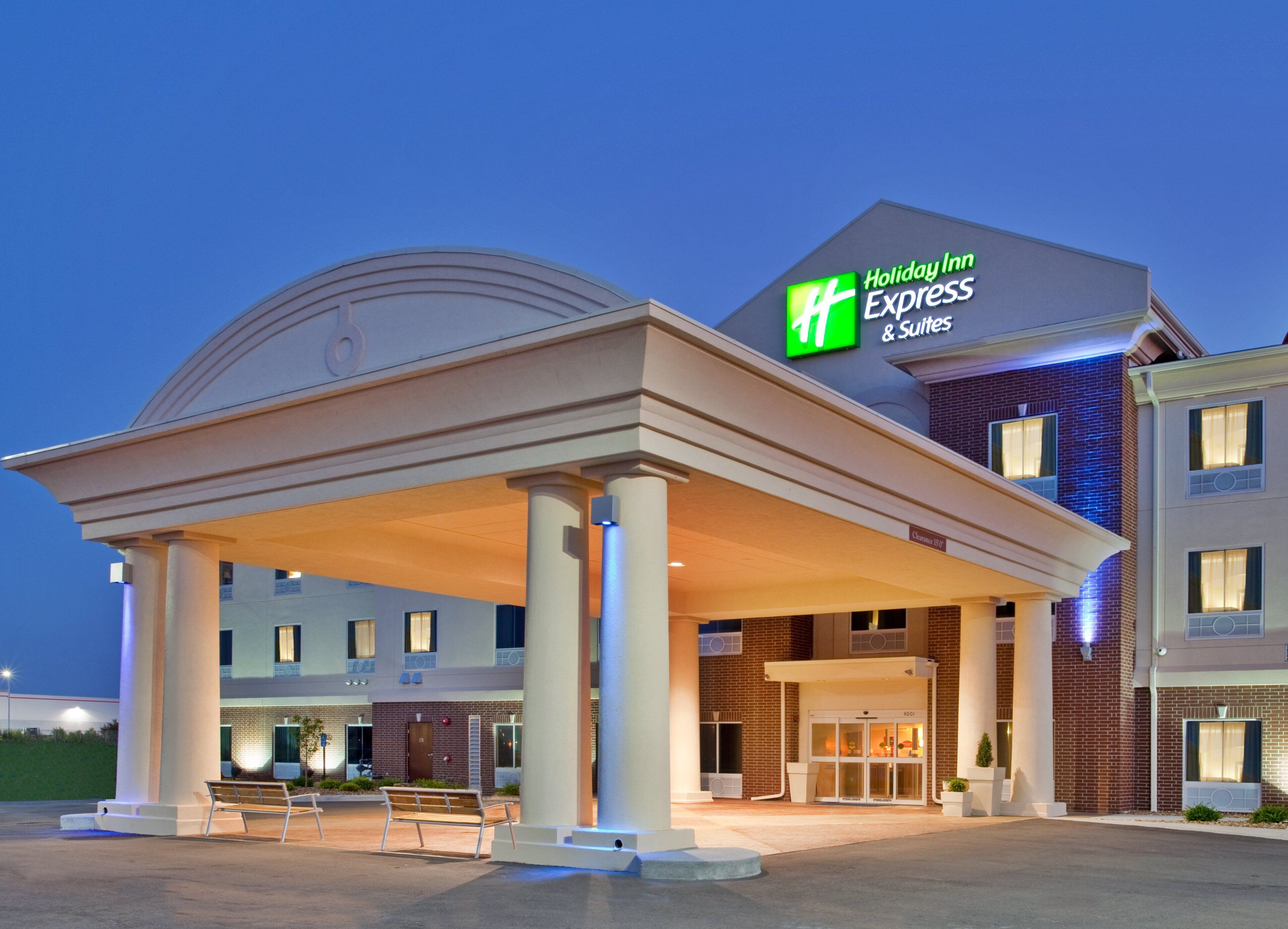 A Holiday Inn Express & Suites building with a covered entrance and a brick facade.