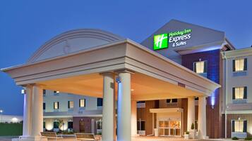 A Holiday Inn Express & Suites building with a covered entrance and a brick facade.
