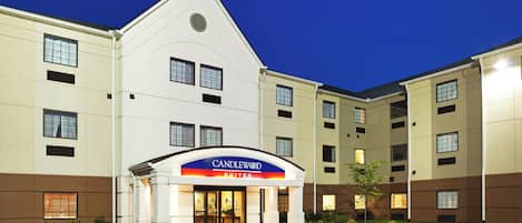 A hotel with a prominent entrance, multiple floors, and a clear sky.