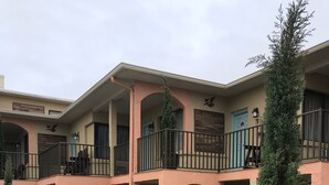 A multi-level outdoor patio with seating areas, potted plants, and a staircase. - San Marina Motel (Daytona Beach)