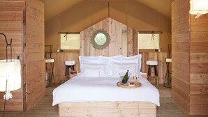 Un dormitorio de cabaña de madera con una cama, una araña y una bandeja de desayuno.