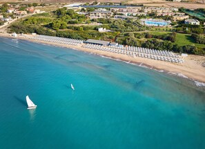 Privatstrand, Liegestühle, Sonnenschirme, Windsurfen