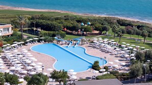 A resort with a large swimming pool, beach area, and numerous sun umbrellas. - Serenusa Resort (Licata)