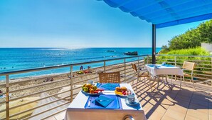 A table set with breakfast items and a view of the beach and ocean. - Hotel Na Forana (Capdepera)