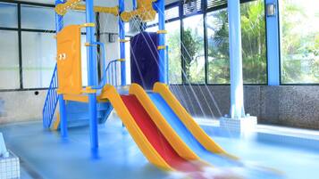 Ein überdachter Wasserpark mit Rutschen und Kletterelementen.