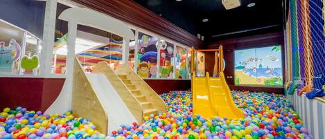 A play area with two slides and a ball pit filled with multicolored balls.
