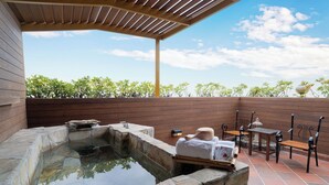 Un espace avec un bain à remous, des murs en pierre, des bancs en bois et une pergola.