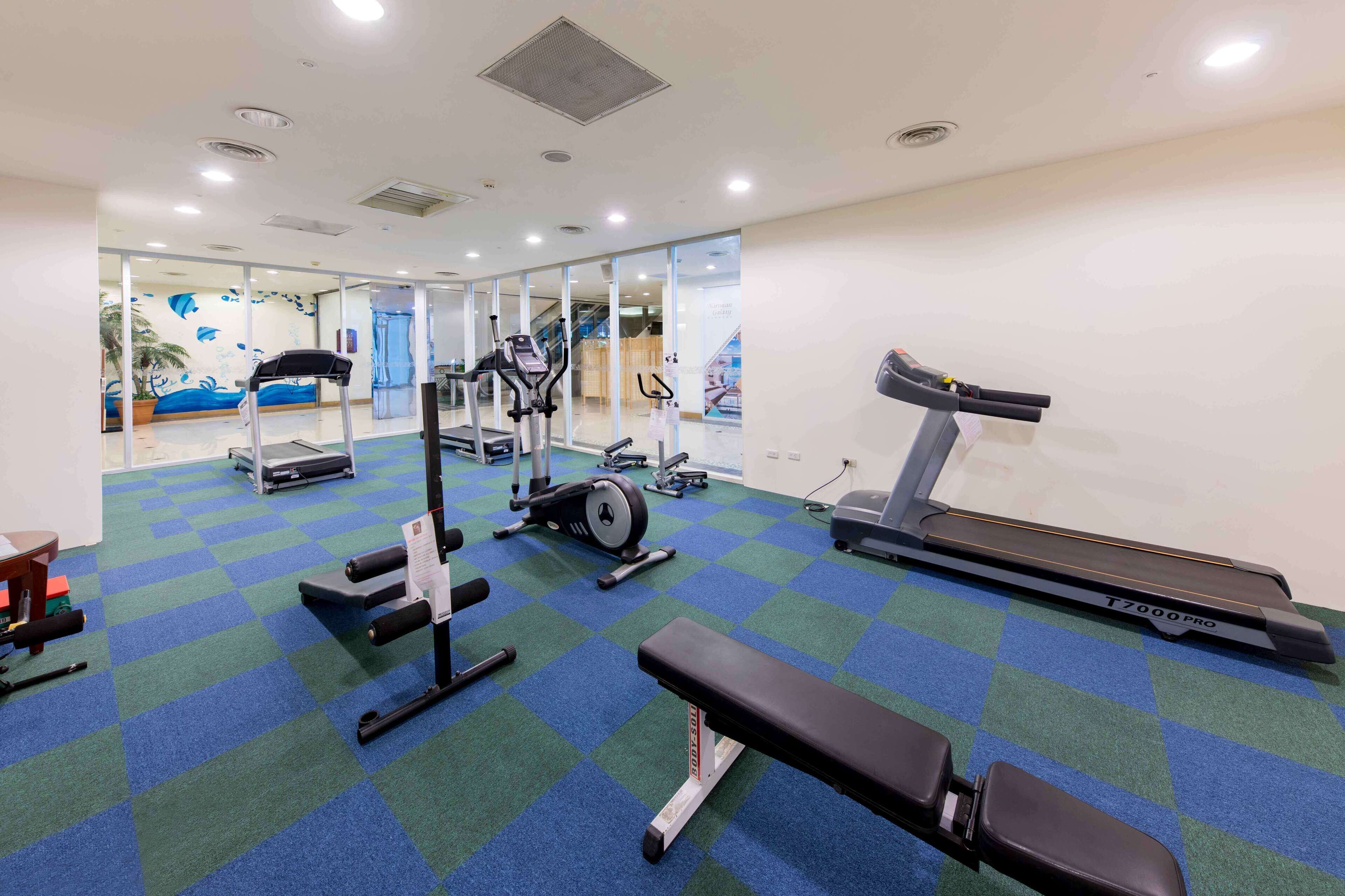 A gym with treadmills, stationary bikes, and weight machines.
