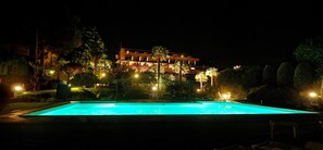 A swimming pool at night with a building in the background. - Wellness & Beauty Hotel Conca Azzurra (Ranco)