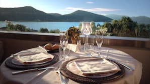 A table set for two with a view of a lake and mountains. - Wellness & Beauty Hotel Conca Azzurra (Ranco)