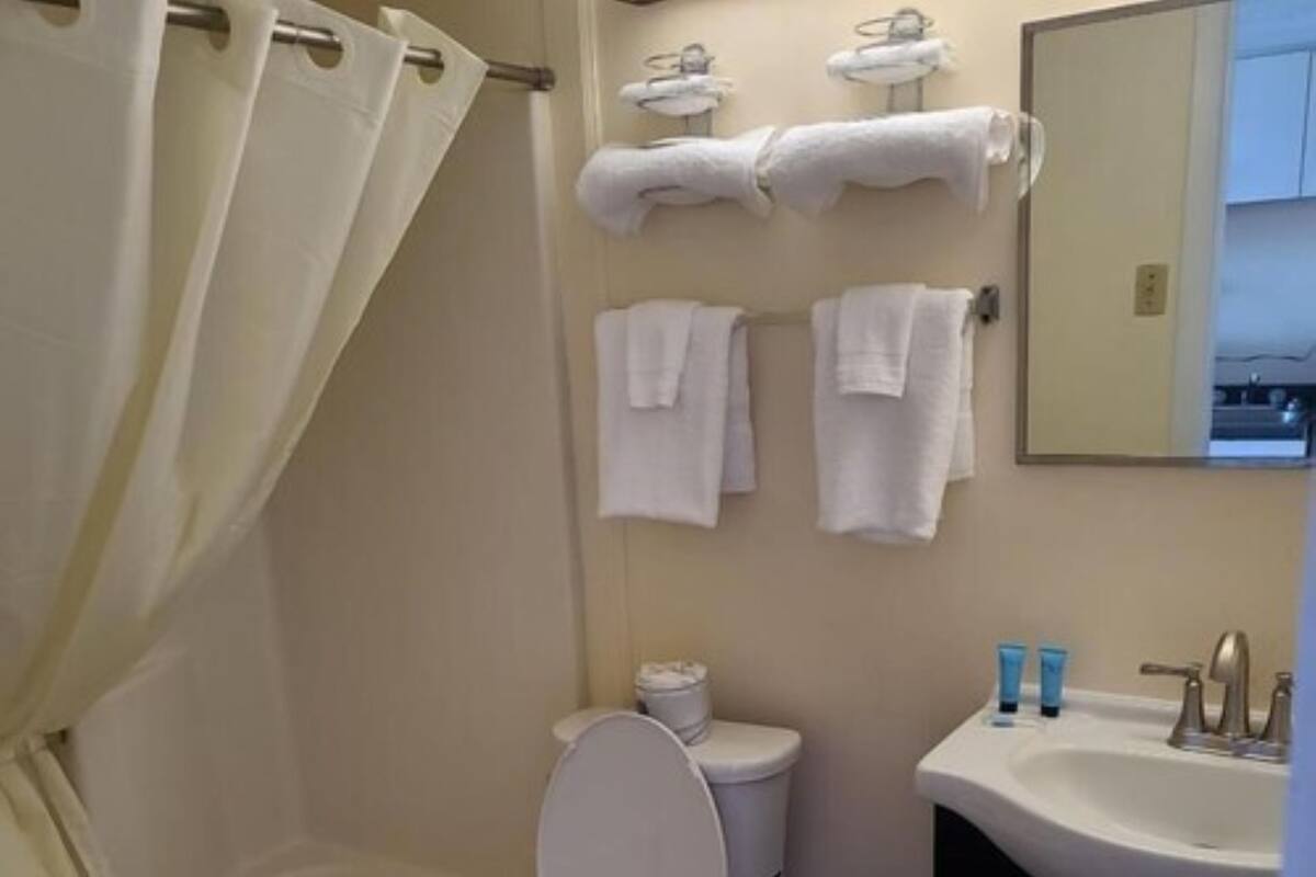 Une salle de bain comprenant des toilettes, une baignoire, un lavabo et un miroir.