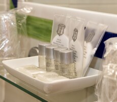 Esillä on erilaisia hygieniatuotteita, kuten pulloja ja tuubeja, todennäköisesti hotellin kylpyhuoneessa.
