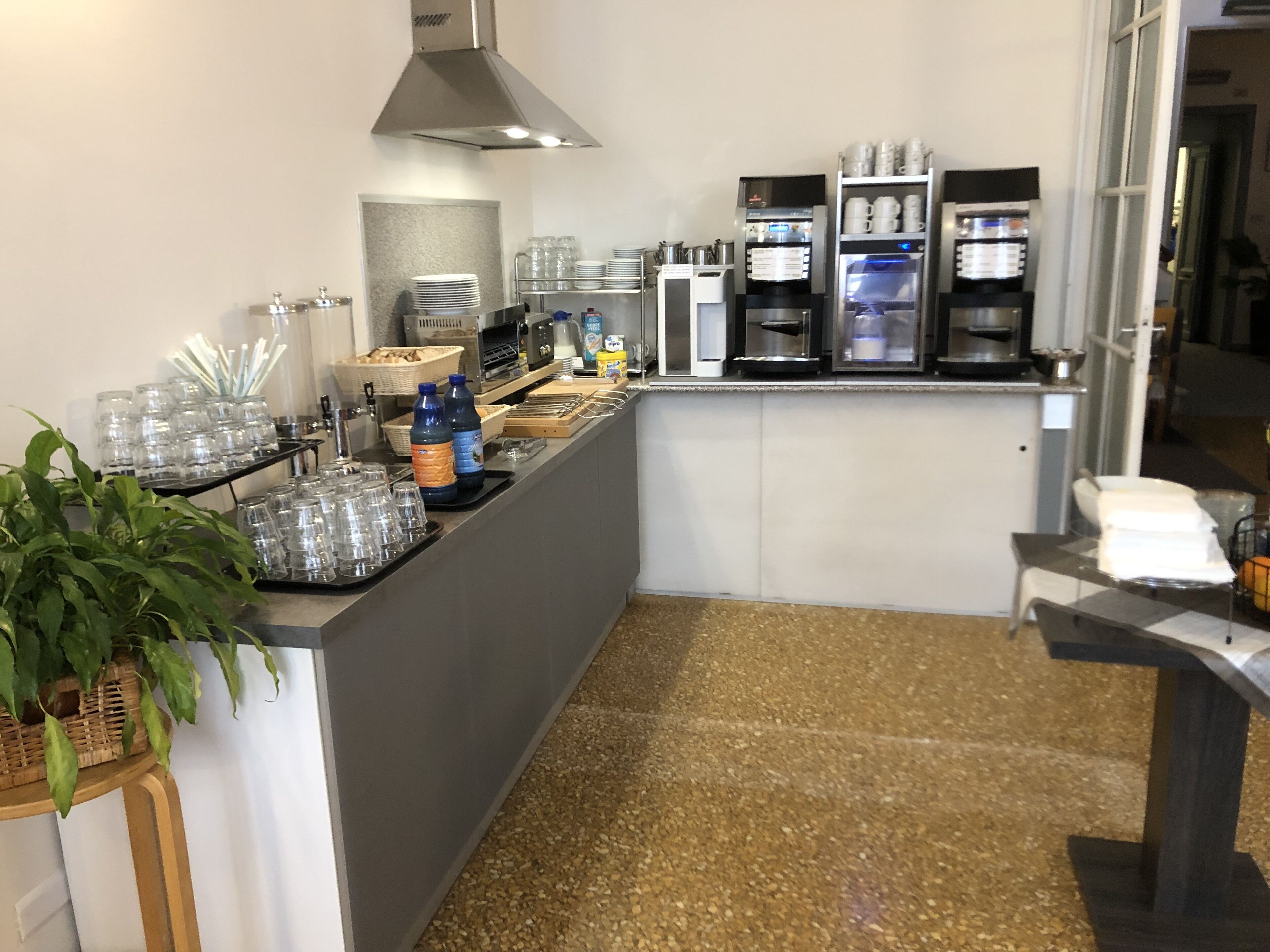 Eine Küchenzeile mit Kaffeemaschine, Wasserspender und verschiedenen Küchengeräten.