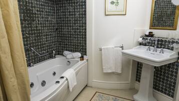 A bathroom with a bathtub, a sink, and a shower area.