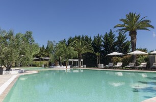 Una piscina al aire libre de temporada, sombrillas