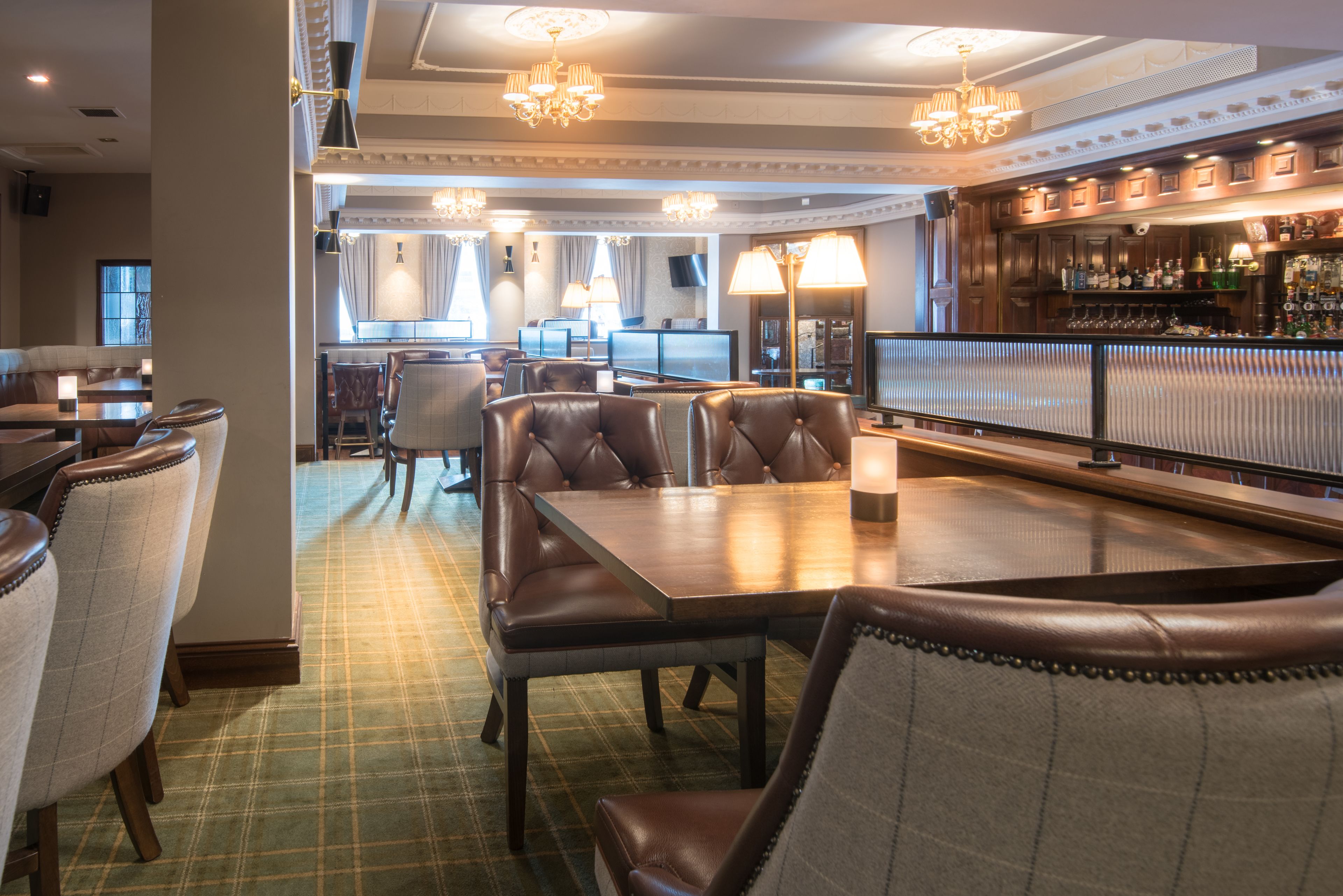 A restaurant with leather seating, a bar area, and a television screen.