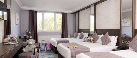 A hotel room with two beds, a desk, a chair, and a window with curtains.