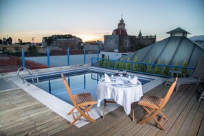 Una piscina al aire libre, sillones reclinables de piscina