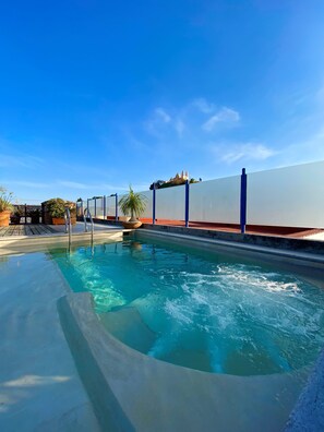 A swimming pool with clear blue water, surrounded by a low wall and potted plants. - Estrella de Belem (San Pedro Cholula)
