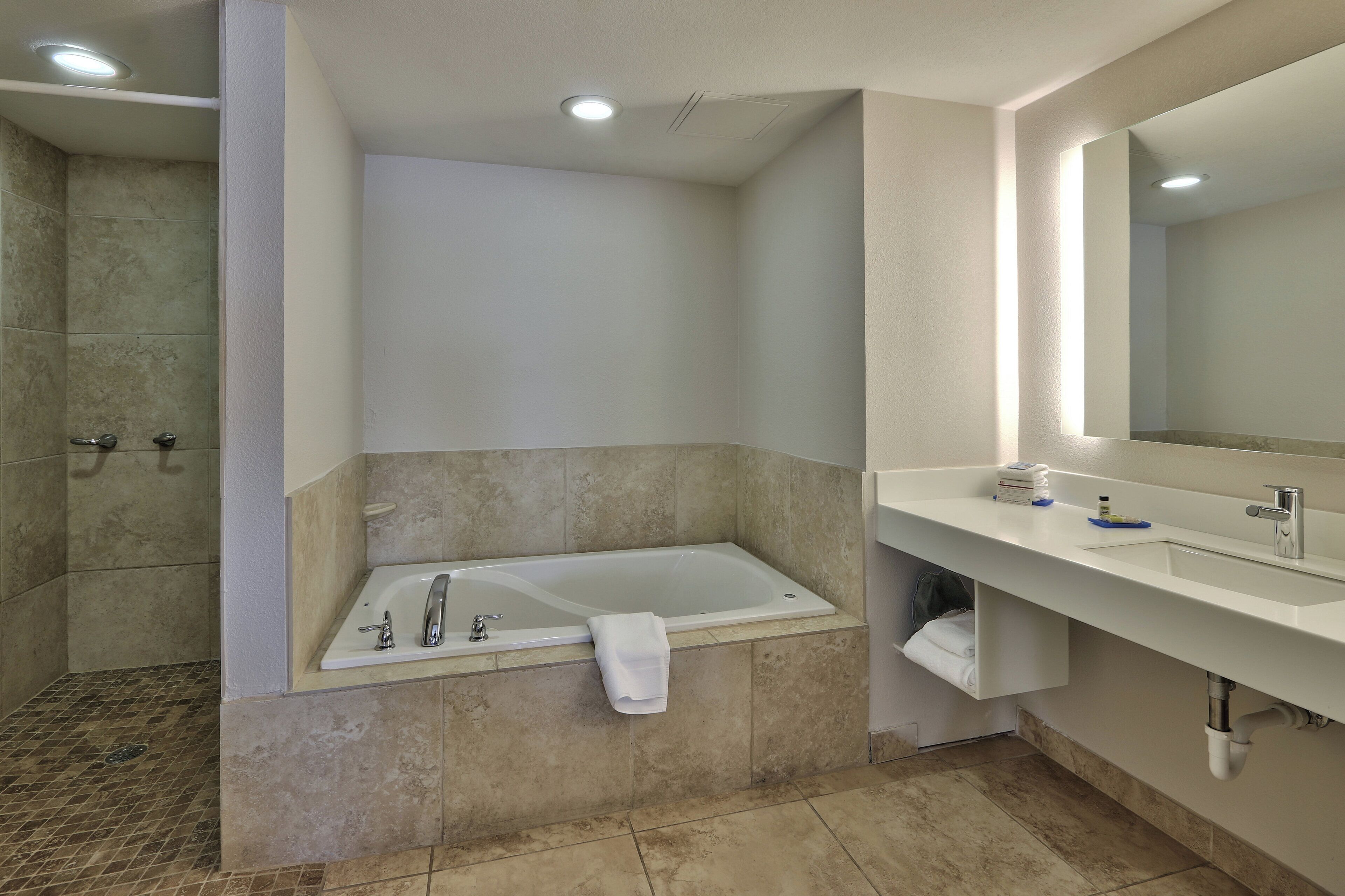 A modern bathroom with a bathtub, a shower, and a sink.