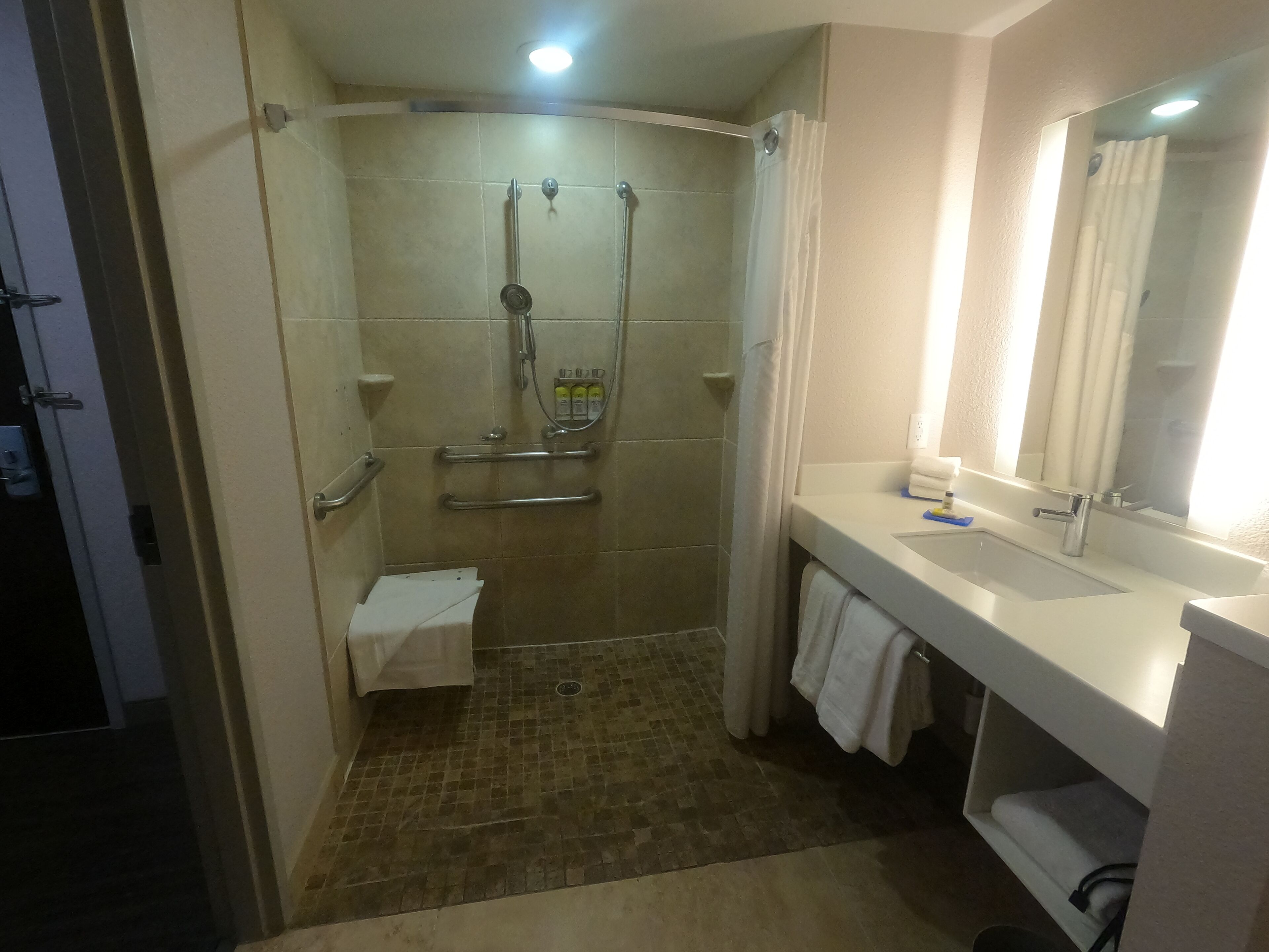 A modern bathroom with a shower, toilet, and sink.