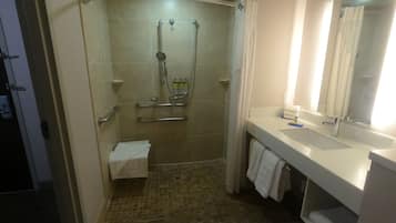 A modern bathroom with a shower, toilet, and sink.