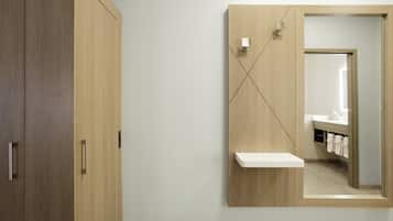 A modern bathroom with a wooden vanity, a mirror, and a towel rack.