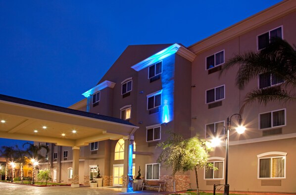 A hotel with a covered entrance, multiple windows, and a well-lit facade. - Holiday Inn Express Los Angeles Airport Hawthorne by IHG (Hawthorne)