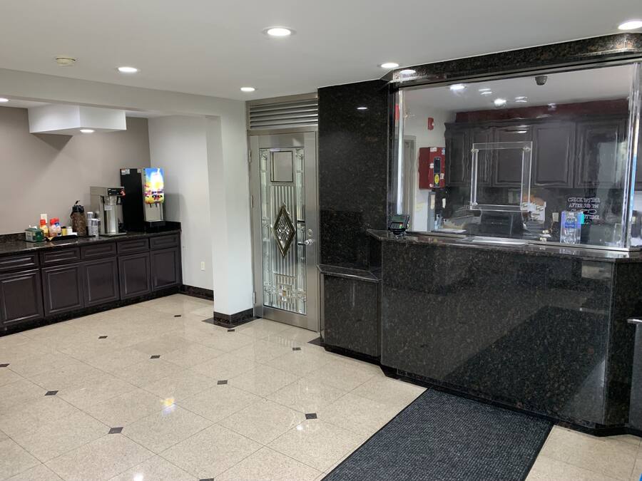 A modern kitchen with a marble countertop, a coffee machine, and a refrigerator.