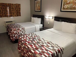 A hotel room with two beds, a wall-mounted air conditioner, and a framed floral painting. - Red Roof Inn Copiague (Copiague)