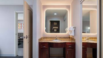 A modern bathroom with a double sink, dark wood cabinetry, and a large mirror.