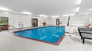 A swimming pool with a clear blue water, surrounded by white walls and a tiled floor. - Hampton Inn Harrison (Harrison)