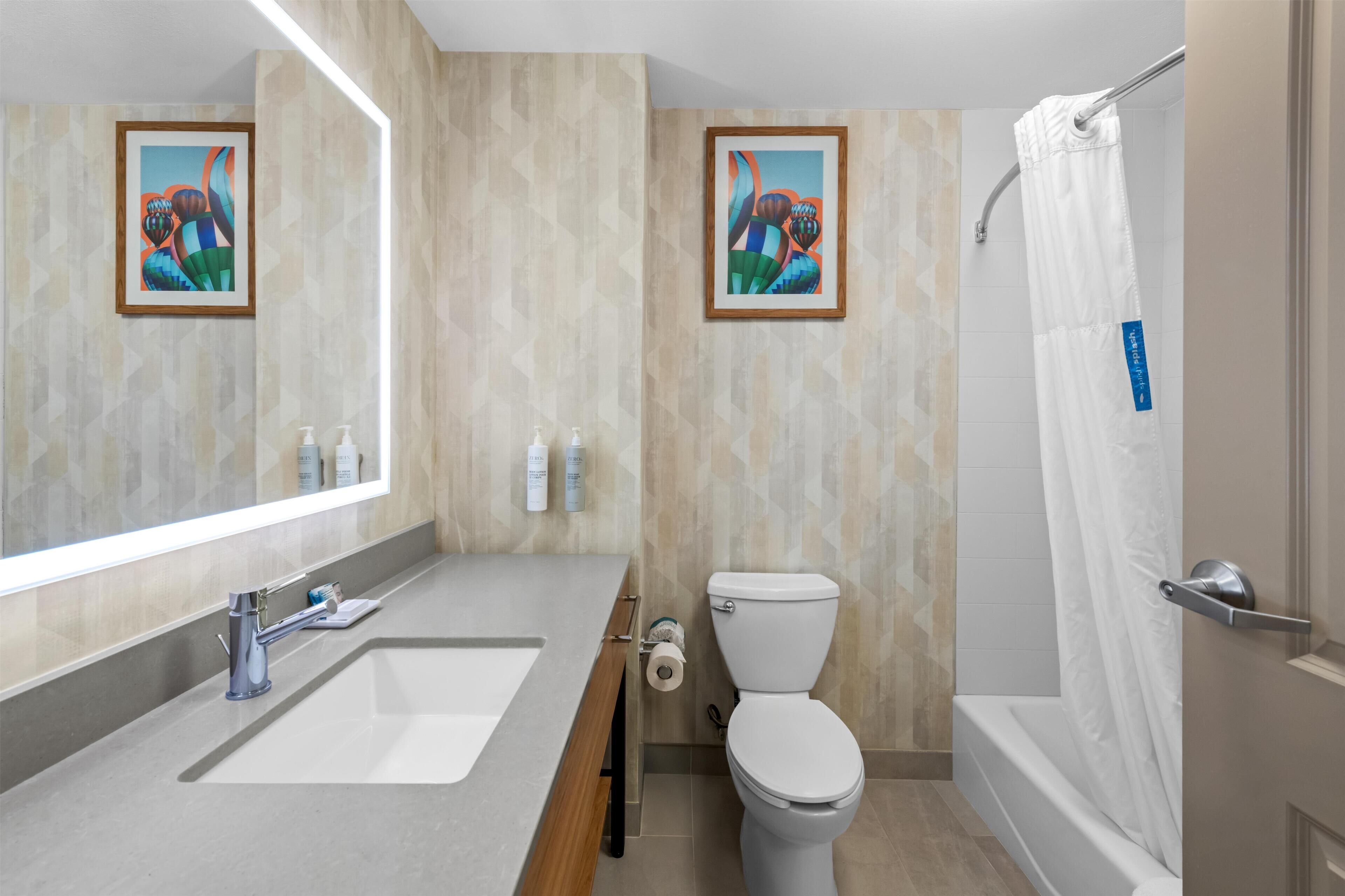Ein modernes Badezimmer mit Waschbecken, Toilette und Dusche.
