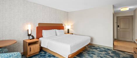 Une chambre d’hôtel comprenant un lit, des tables de chevet, un bureau et une chaise.
