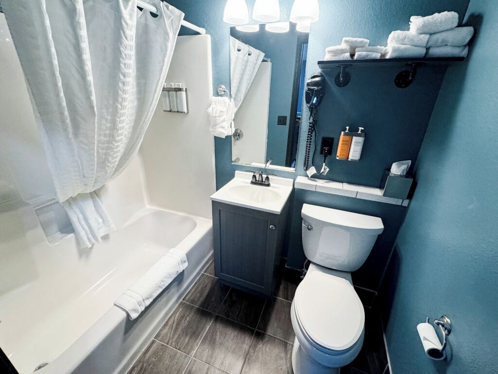 A bathroom with a bathtub, toilet, and sink.