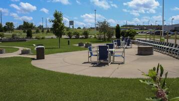 A park with outdoor seating and a parking lot.