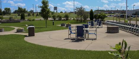 A park with outdoor seating and a parking lot.